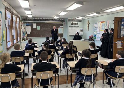 Second graders enjoy visiting with the bishop.