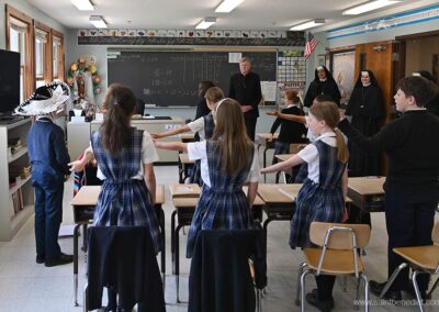 The third grade performs a poem for Bishop McManus